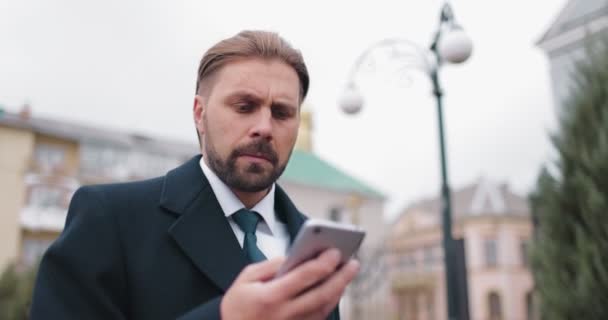 Businessman using smartphone for work outdoors — Stock Video