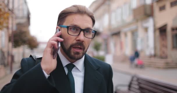 スーツを着た男が路上で電話を拾う — ストック動画