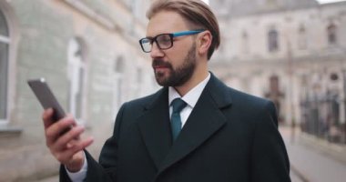 Sokakta cep telefonu kullanan şık bir işadamı