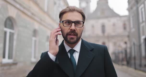 Предприниматель в очках говорит по мобильному телефону — стоковое видео