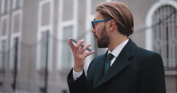 ビジネスマンがスマートフォンで音声メッセージを録音する — ストック動画