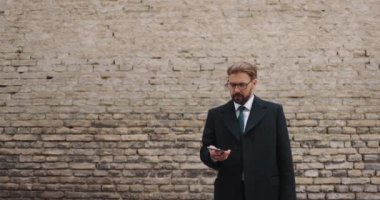 İş adamı cep telefonuyla dışarıda arama yapıyor.