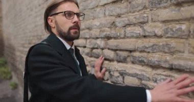 Korkak işadamı tuğla duvarın yanında sürünüyor.