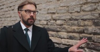 Tuğla duvarın arkasında saklanan ürkütücü iş adamı