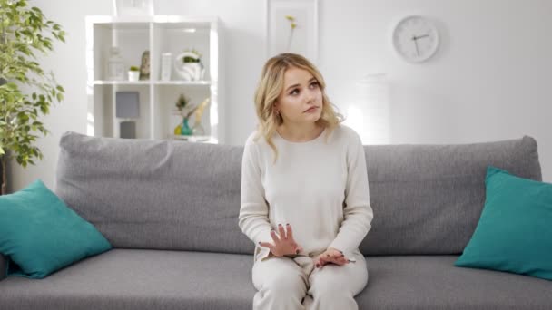 Жінка сидить на дивані і чекає — стокове відео