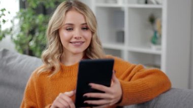 Kanepede tablet kullanan rahat kadın.