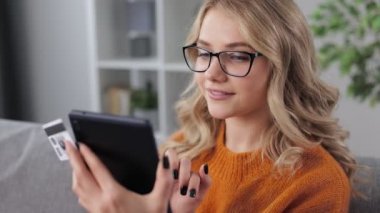 Kanepede online alışveriş yapan bir kadın