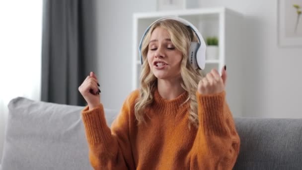 Glædelig dame lytter sange i hovedtelefoner – Stock-video