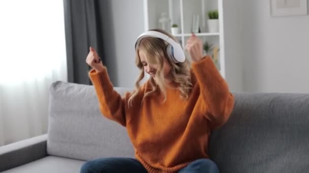 Mulher em fones de ouvido curtindo música no sofá — Vídeo de Stock
