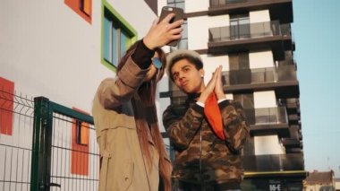 Sokakta selfie çeken genç çift.