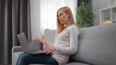 Video görüşmesi sırasında konuşan ve el kol hareketi yapan kadın.