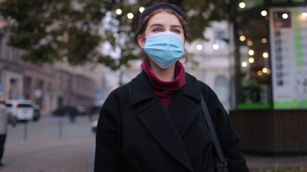 Kvinna stående utomhus i medicinsk mask — Stockvideo