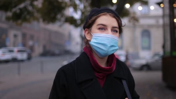 Brunette in medisch masker wandelen in stree — Stockvideo