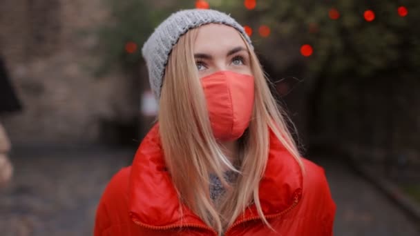 Bionda indossa maschera rossa mentre cammina — Video Stock