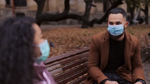 Multiculturele mensen zitten op een bank met maskers — Stockvideo