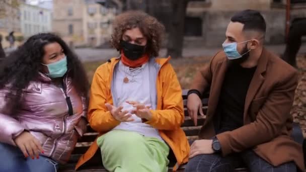 Happy people sitting at park in medical masks — Stock Video