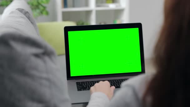 Mujer sosteniendo portátil con pantalla vacía en el sofá — Vídeos de Stock