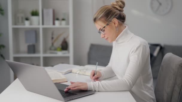 Mulher de óculos estudando no laptop — Vídeo de Stock