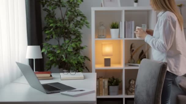 Vrouw die aan tafel zit en laptop gebruikt — Stockvideo