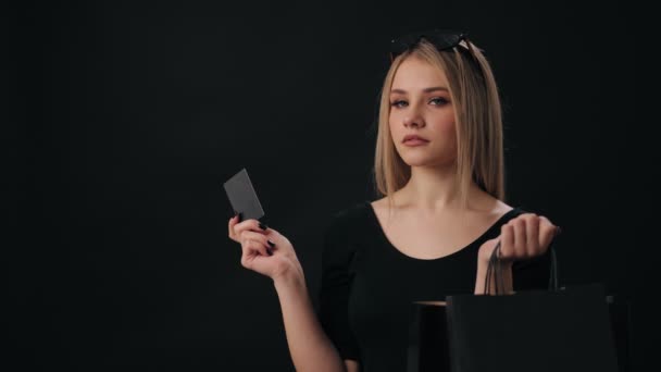 Жінка тримає кредитну картку і сумки для покупок — стокове відео