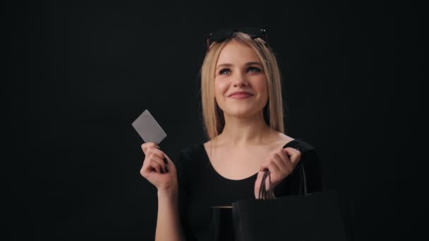 Žena s kreditní kartou a nákupními taškami ve studiu — Stock video
