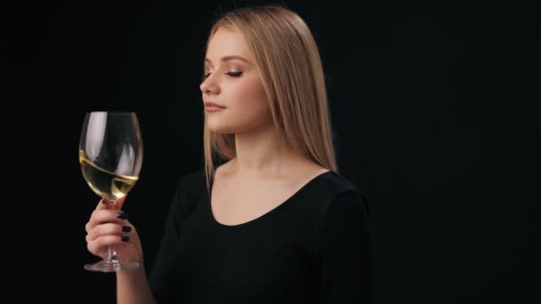 Женщина нюхает белое вино в стакане — стоковое видео