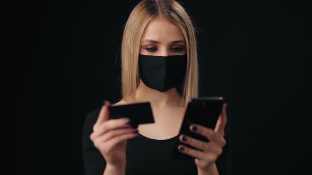 Kvinna i svart mask med online shopping — Stockvideo