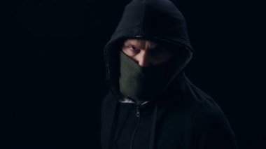 Maskeli hırsız silahla nişan alıyor.