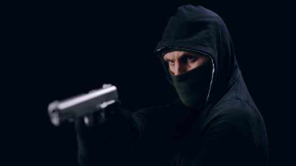 Maskovaný lupič míří pistolí — Stock video