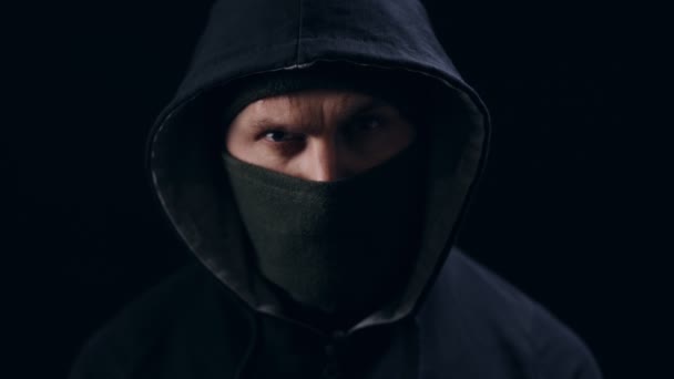 Portrét seriózního muže v černé masce a kapuci — Stock video