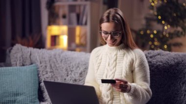 Alışveriş için dizüstü bilgisayar ve kredi kartı kullanan bir kadın