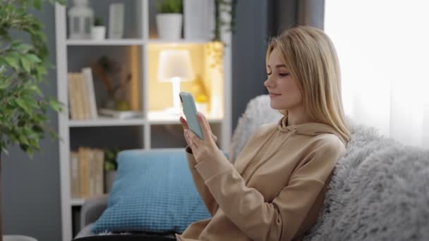 Positive Weibchen nutzen Smartphone zu Hause — Stockvideo