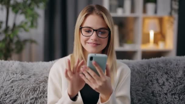 Žena pomocí chytrého telefonu na gauči — Stock video