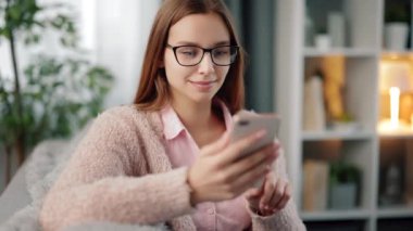 Evde cep telefonu kullanan rahat bir kadın.