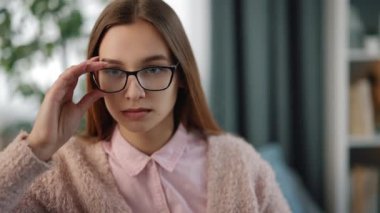 Yorgun bir kadın gözlerini kanepeye sürtüyor.