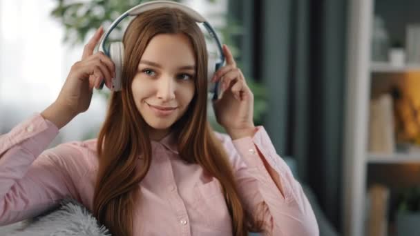 Žena poslouchá písně ve sluchátkách doma — Stock video