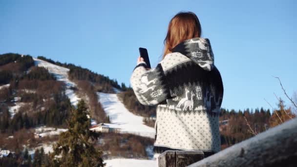Mujer tomando fotos en smartphone de montañas nevadas — Vídeos de Stock