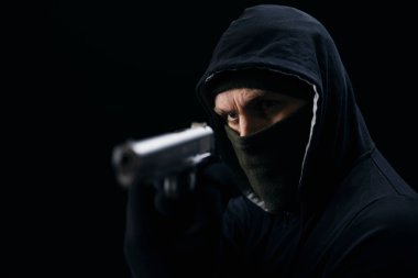 Maskeli kızgın gangster silah taşıyor.