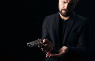 Ağır suçlu silahtan boş şarjör çıkarıyor.