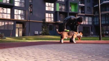 Mutlu adam sokakta köpeğini okşuyor.