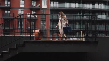 Şehir bölgesinde teslimat kutusu taşıyan bir kadın kurye.