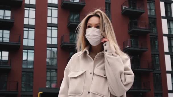 Жінка знімає медичну маску на відкритому повітрі — стокове відео