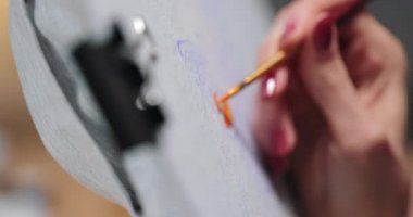 Kadın ressamların tişörtlerine resim yaparken yakın plan