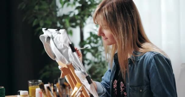 Artista femenina usando pincel para pintar en camiseta — Vídeos de Stock