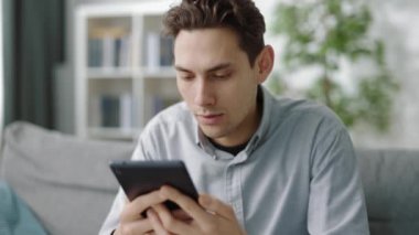 Tabletle koltukta oturan tatmin olmuş bir adam.