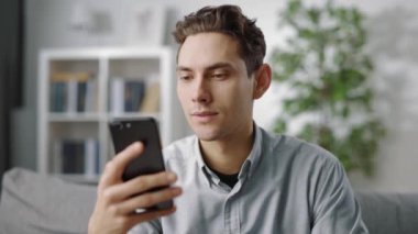 Akıllı telefonlu kanepede dinlenen yakışıklı.
