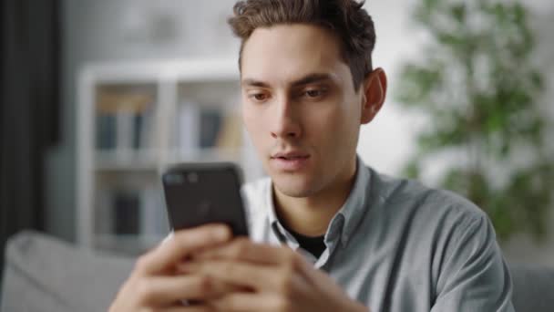 Jonge man met smartphone thuis — Stockvideo