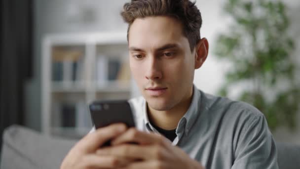 Zufriedener Mann tippt Nachrichten auf Smartphone — Stockvideo