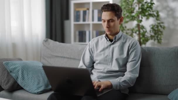 Zaměřený muž pracující na notebooku doma — Stock video