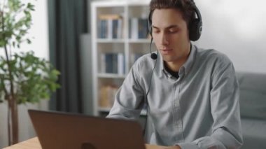 Video araması için bilgisayarı kullanan kulaklıklı bir adam.